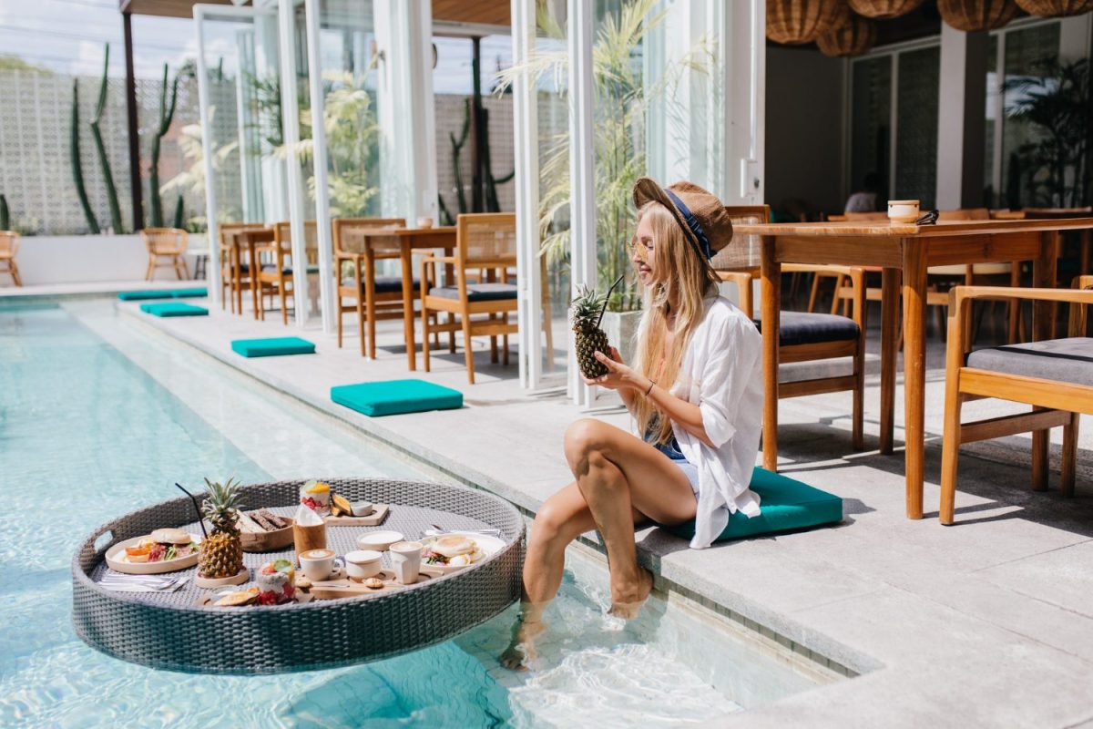 femme bord piscine dans hôtel de luxe