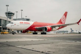 Avion Air India au sol sur le tarmac d'un grand aéroport international avec livrée rouge et blanche distinctive