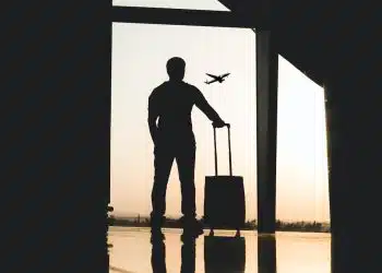 silhouette of man holding luggage inside airport