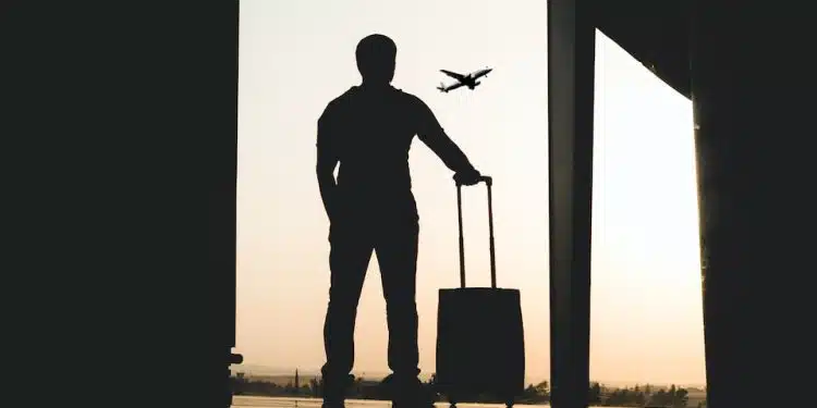 silhouette of man holding luggage inside airport