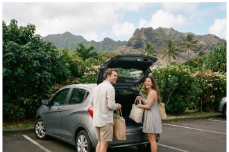 Jeune couple souriant à côté d'une voiture à La Réunion