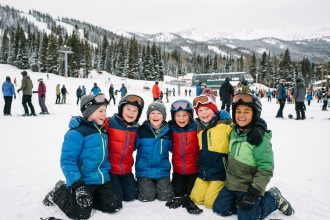 Enfants souriants en ski sur une pente enneigee