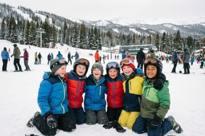 Enfants souriants en ski sur une pente enneigee