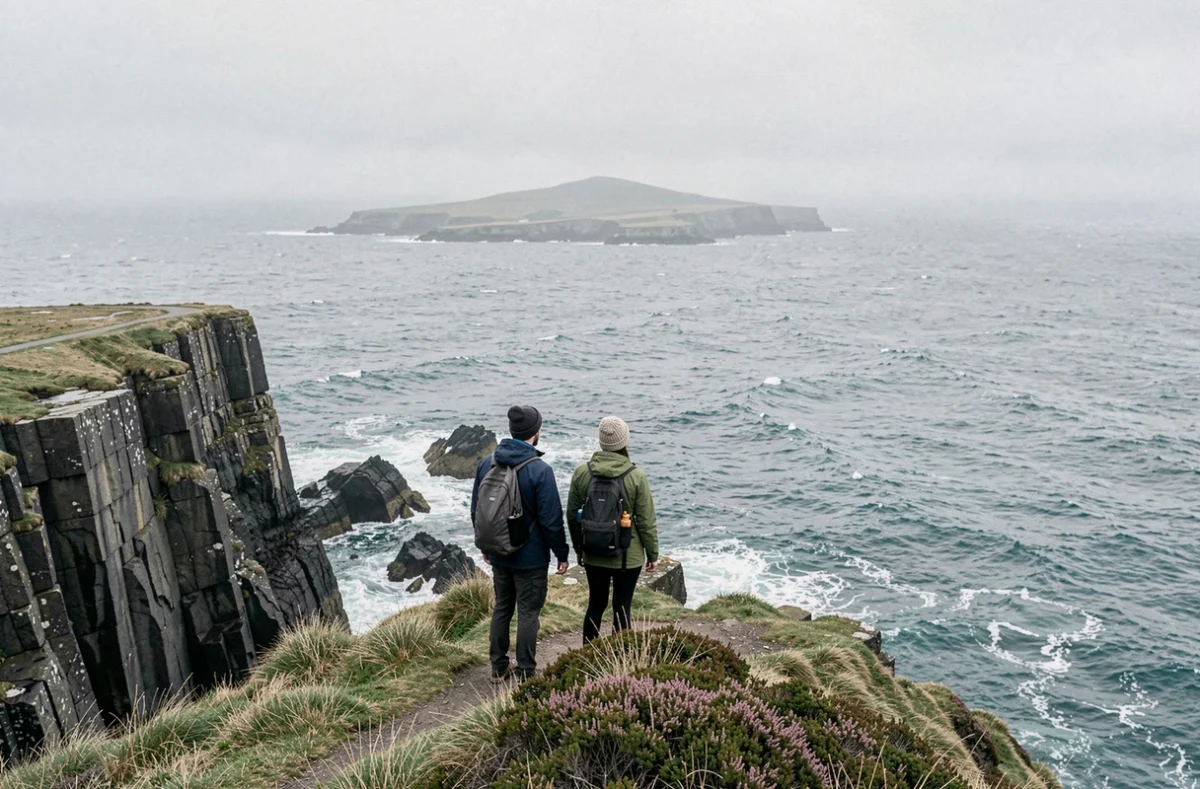 Deux randonneurs au sommet de la Pointe du Raz contemplant l'océan Atlantique et l'île de Sein